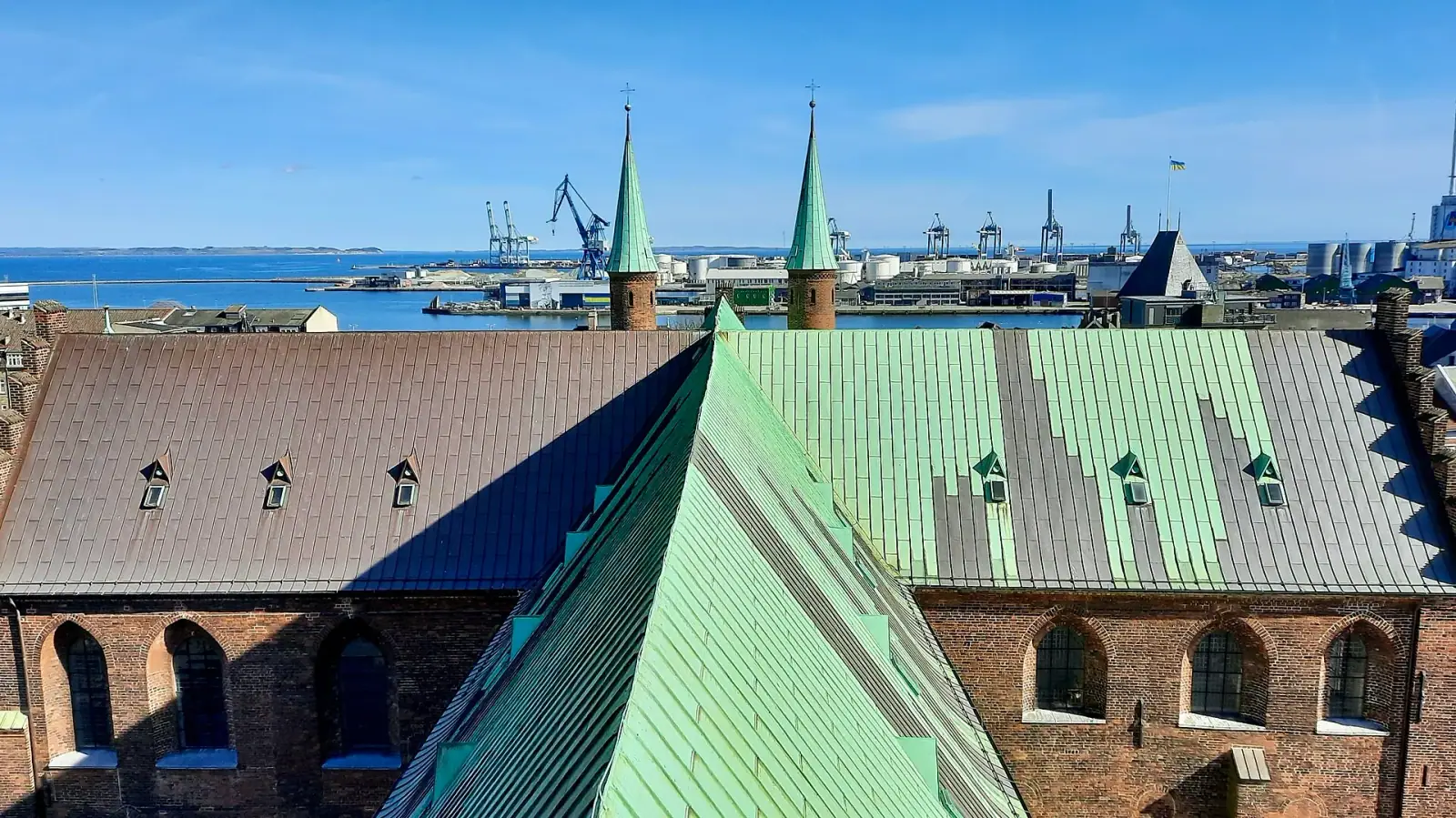 View from Aarhus Cathedral bell tower over the city rooftops, green copper spires, and harbor beyond