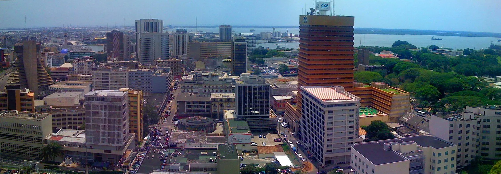 Wide daytime panorama of the Plateau business district in Abidjan with high rise towers along the Ebrie Lagoon