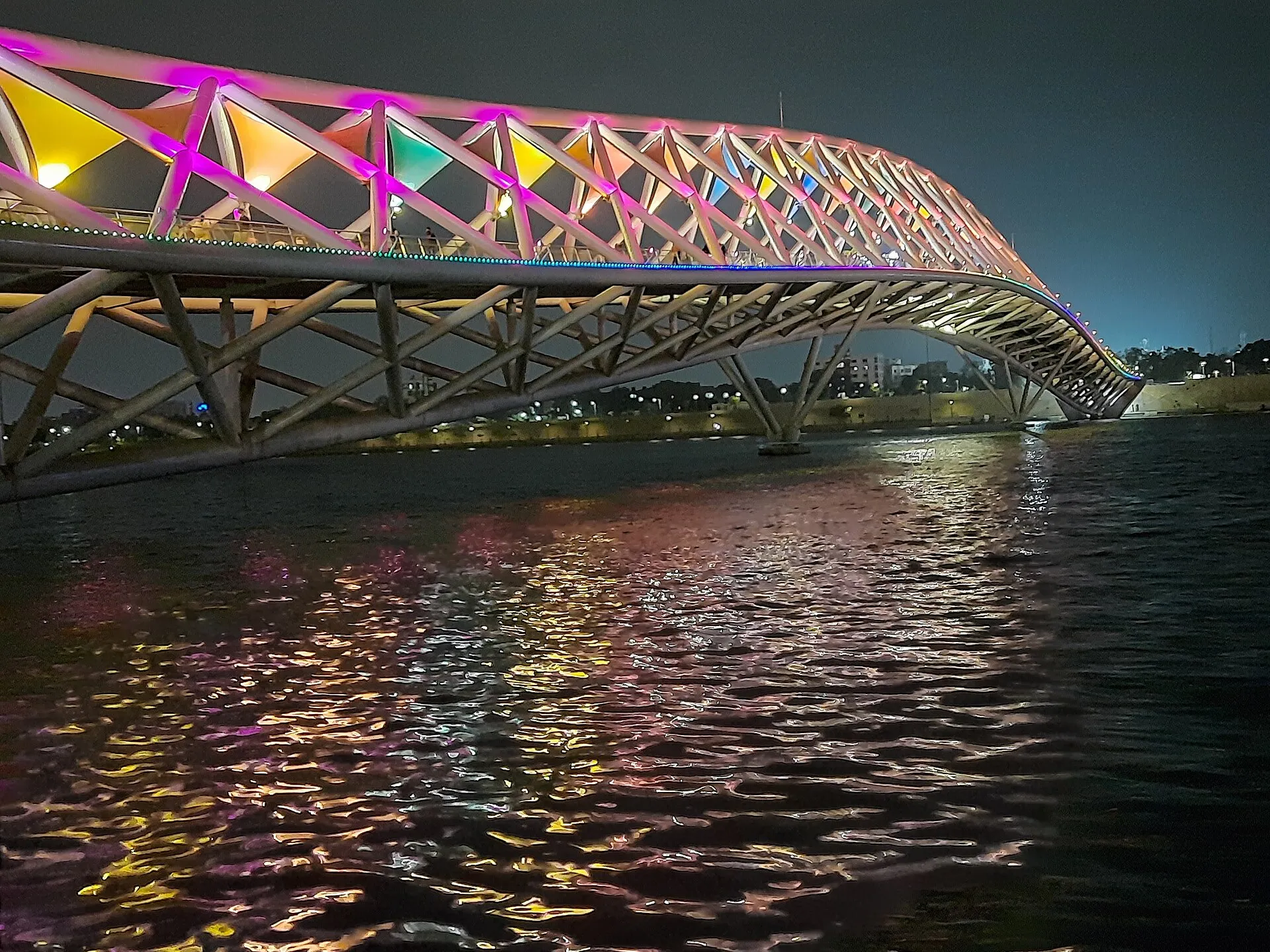 The colourfully lit Atal Pedestrian Bridge over the Sabarmati Riverfront in Ahmedabad at night