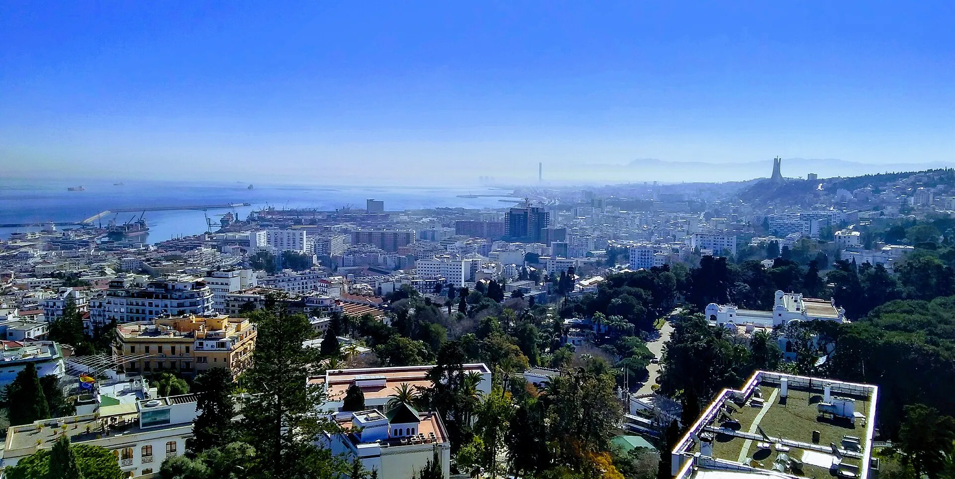 Sunlit panorama of Algiers looking down over the white terraced city, the port and the wide Mediterranean bay