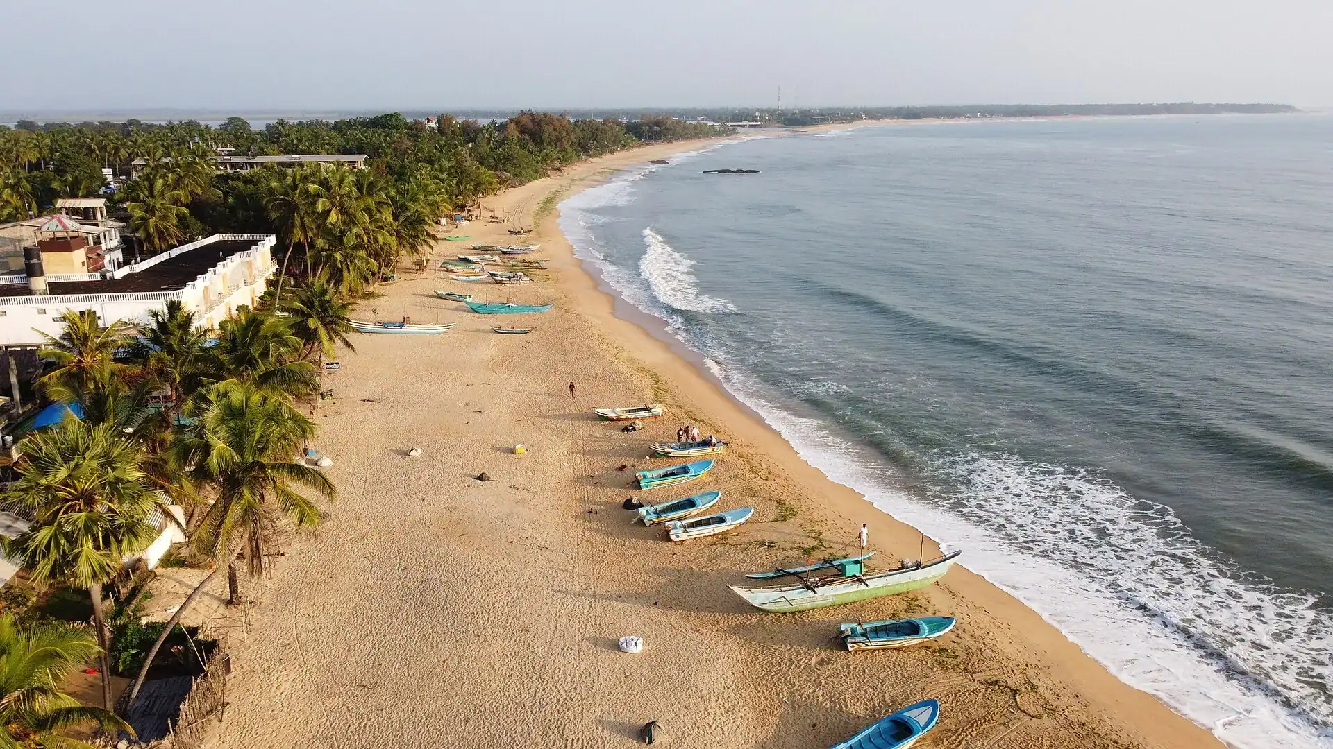 The sweep of Arugam Bay with fishing boats drawn up on the sand