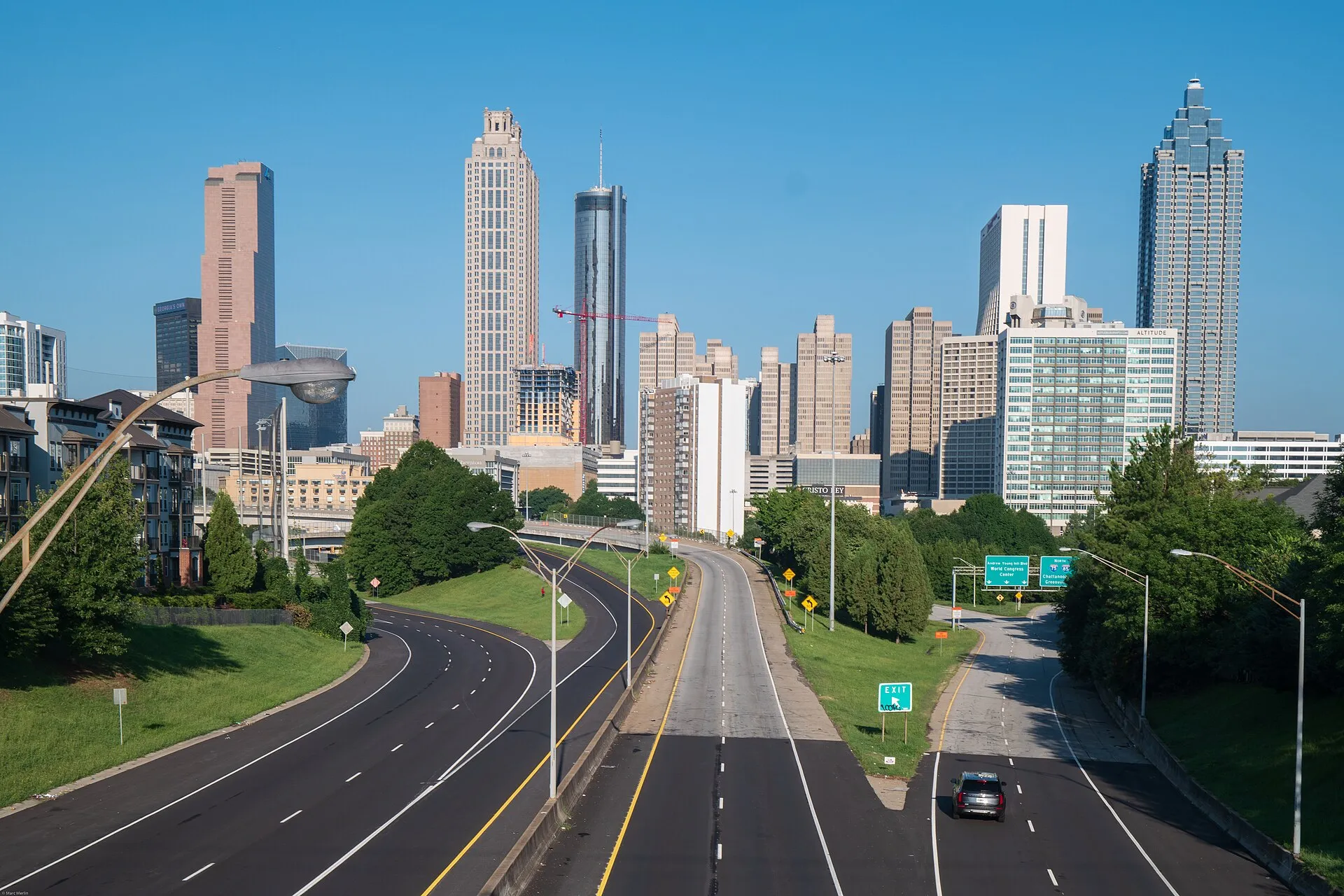 The downtown Atlanta skyline under a clear blue sky, seen looking down the freeway from the Jackson Street Bridge