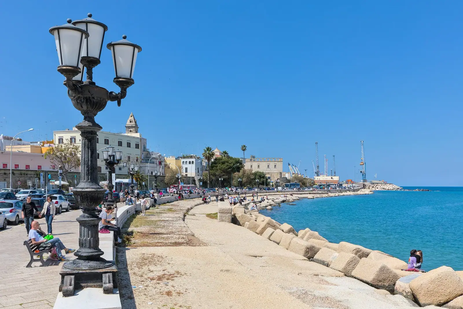 Bari lungomare promenade with ornate lampposts, Adriatic Sea, and old town skyline on a sunny day
