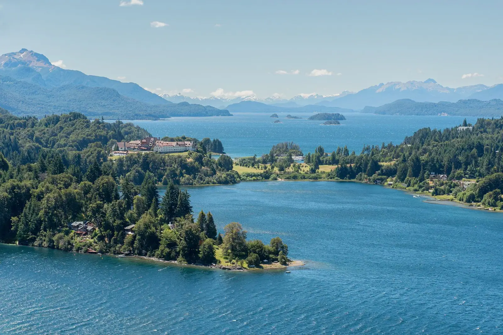Aerial view of Llao Llao peninsula with the iconic hotel, Nahuel Huapi lake, and snow-capped Andes mountains, Bariloche, Argentina