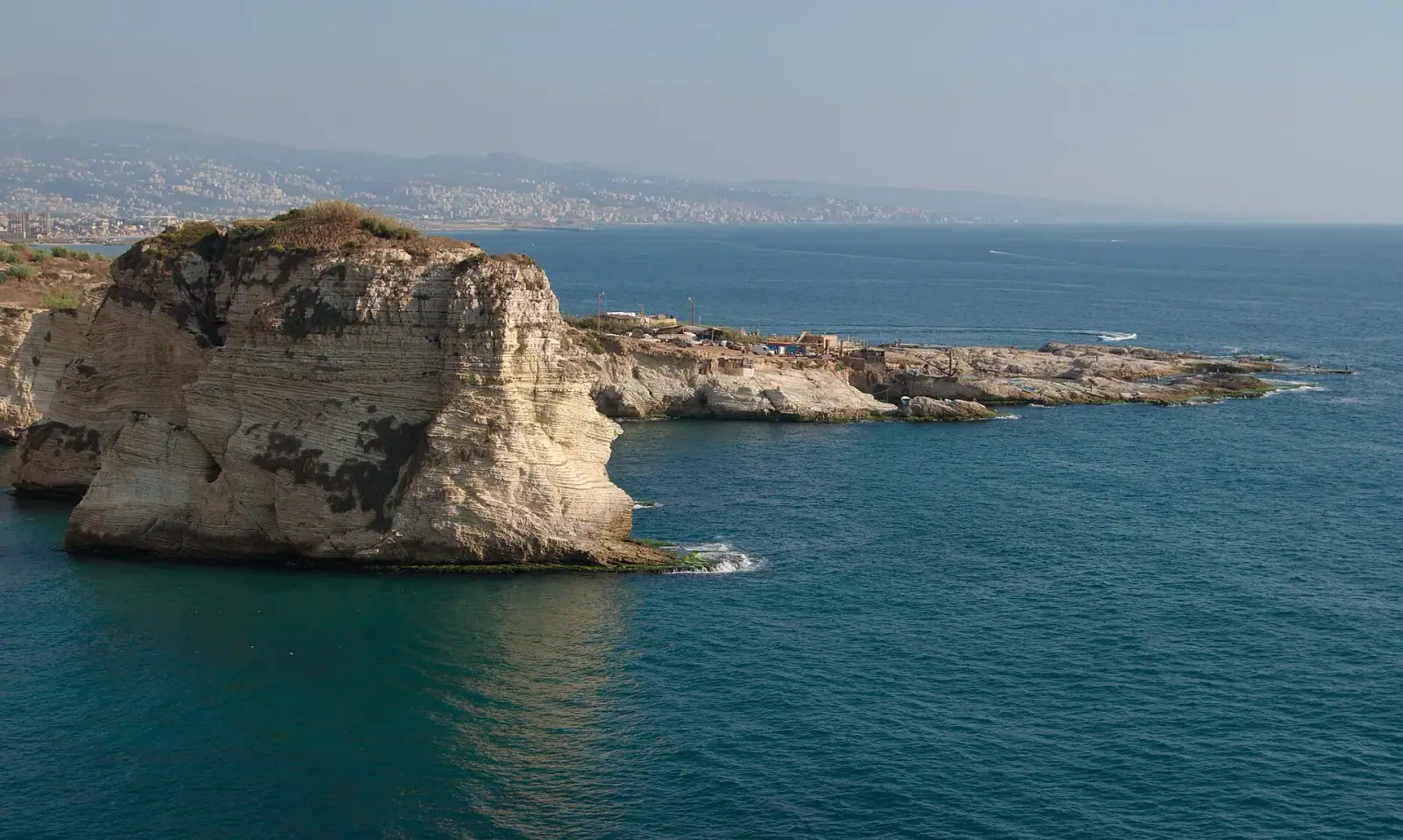Pigeon Rocks (Raouche) sea stacks with Beirut city and Lebanese mountains behind