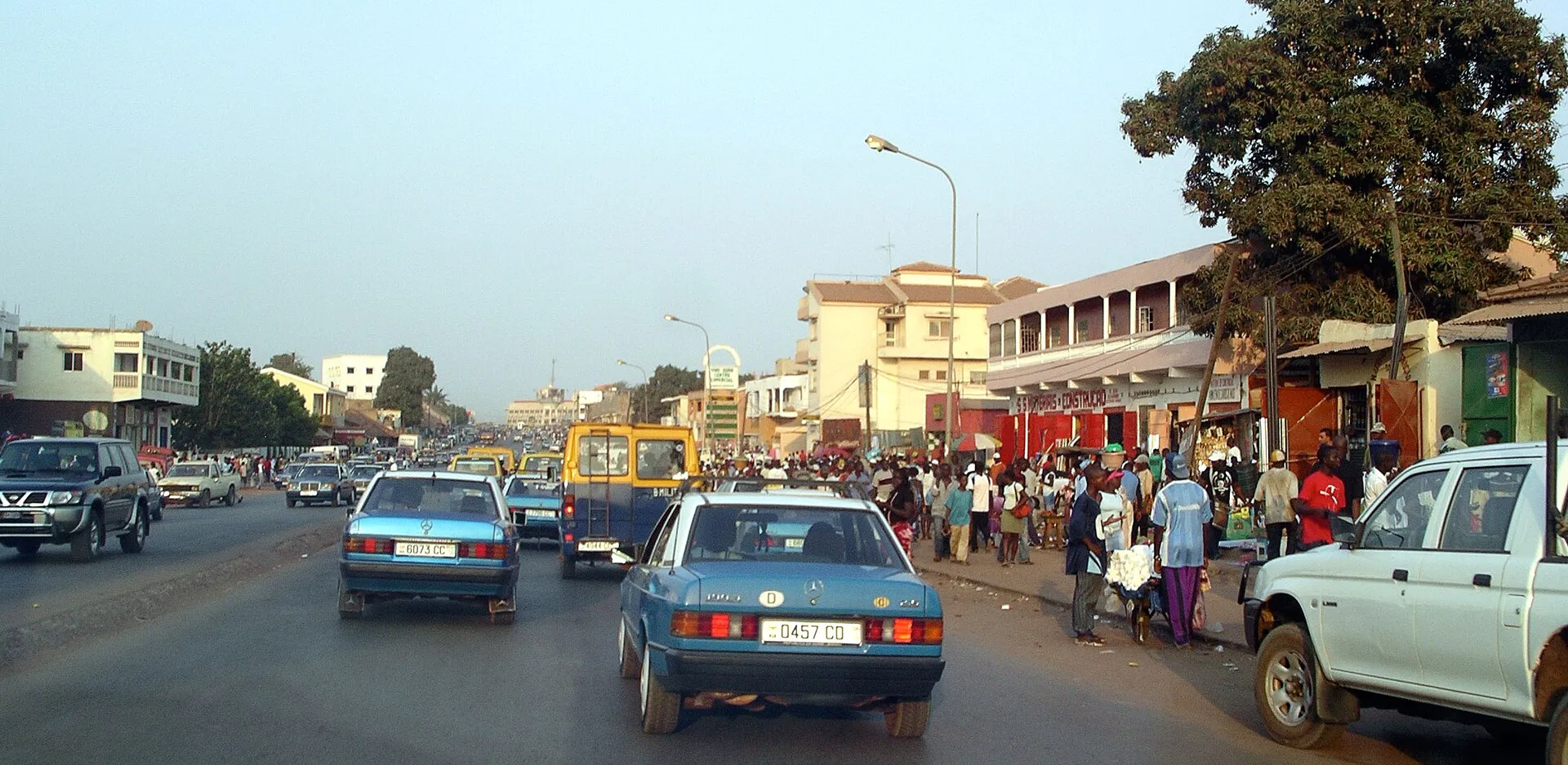 A main street in Bissau, lined with its blue shared taxis