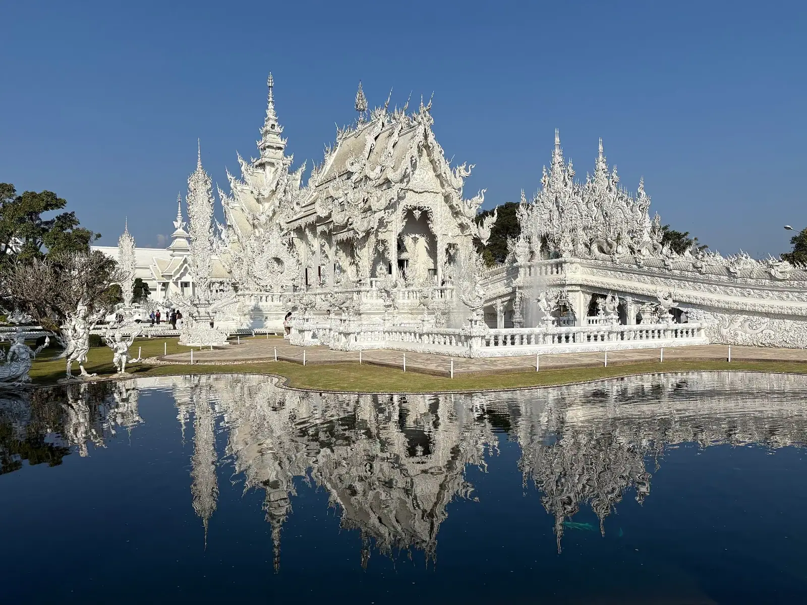 Wat Rong Khun White Temple reflected in moat, Chiang Rai, Thailand