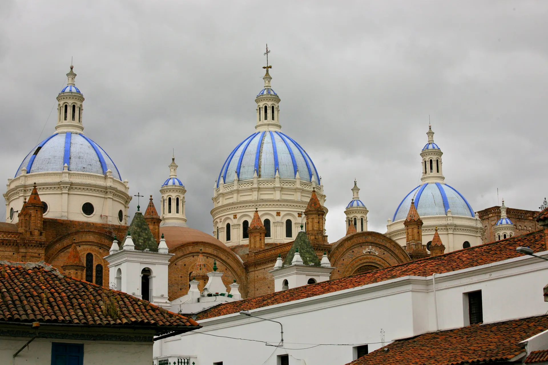 Blue-and-white domes of the New Cathedral above the roofs of Cuenca, Ecuador