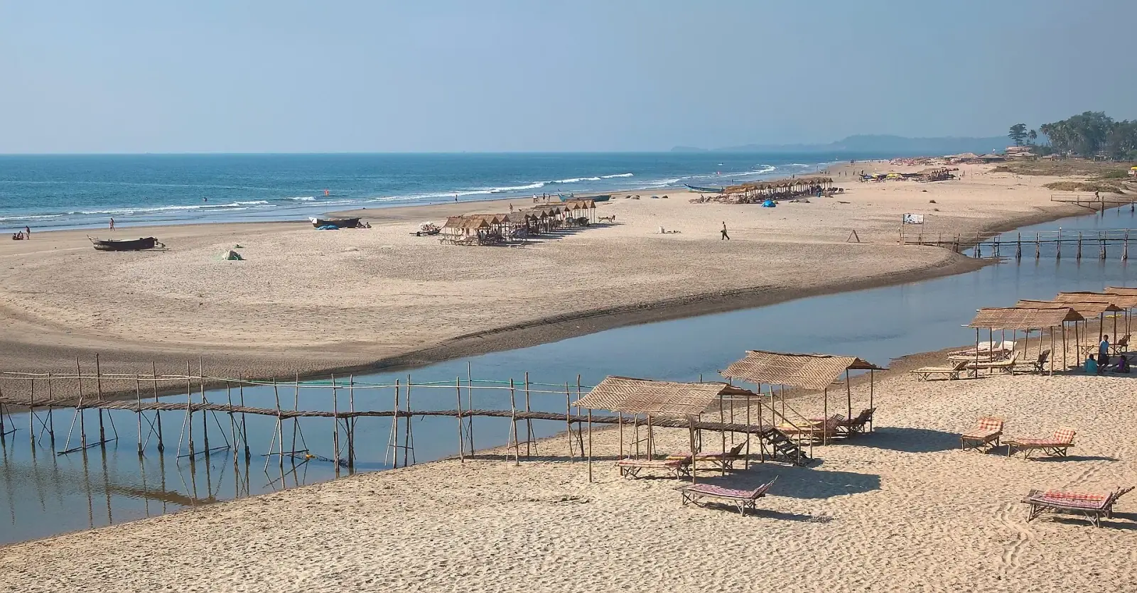 Mandrem Beach and Mandrem River in North Goa, India, with bamboo footbridge and beach shacks