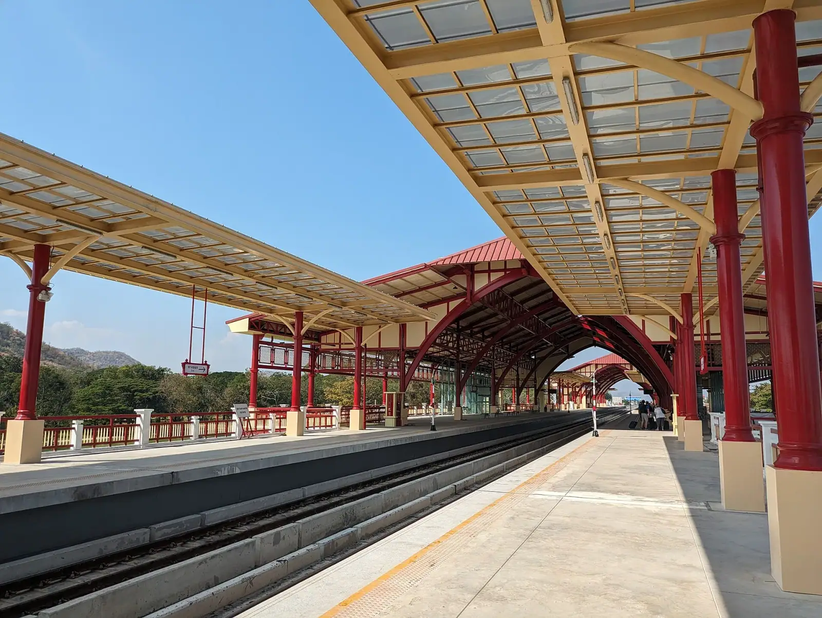 Hua Hin Railway Station platform with ornate red colonial canopy and blue sky