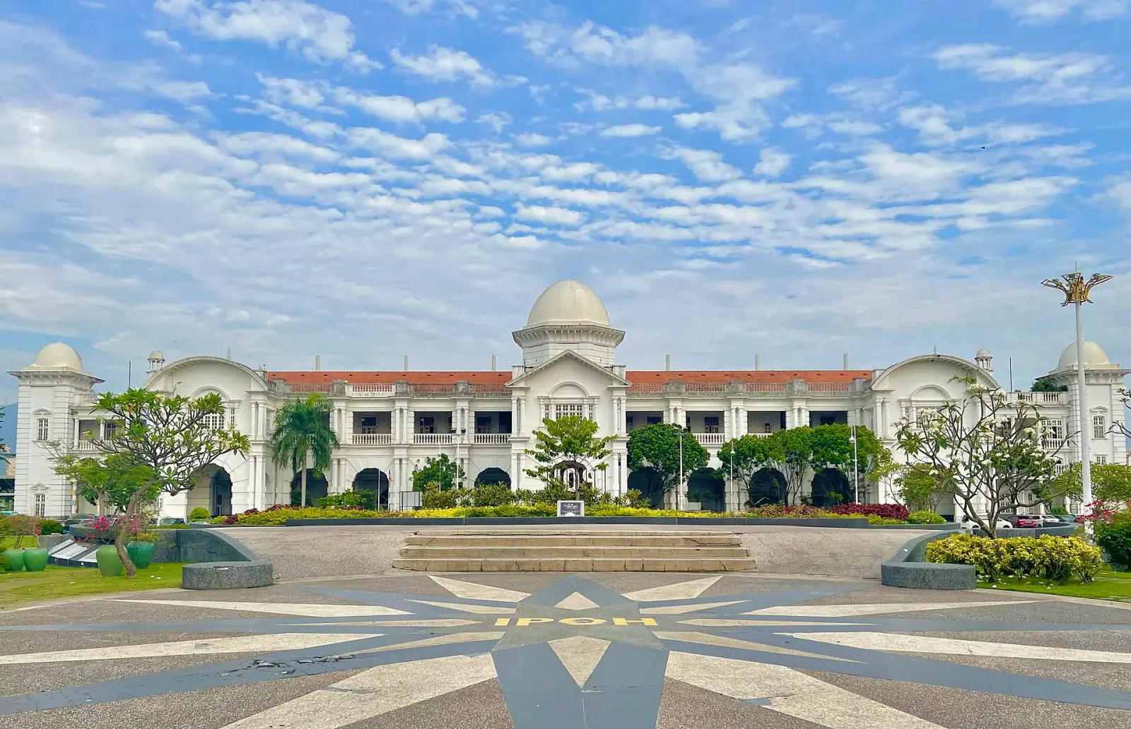 Ipoh Railway Station colonial white facade with IPOH lettering in foreground pavement