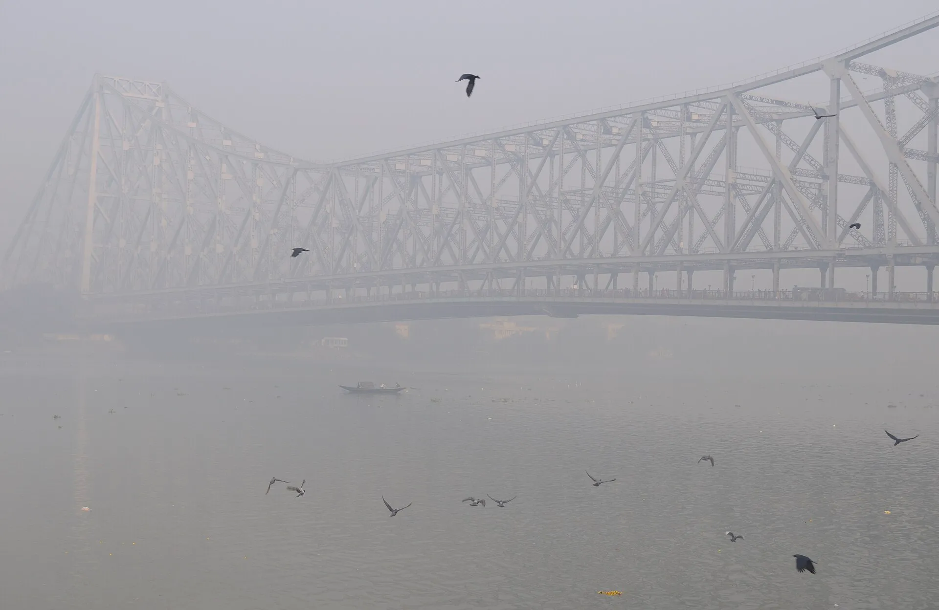 The Howrah Bridge over the Hooghly River in Kolkata on a misty morning