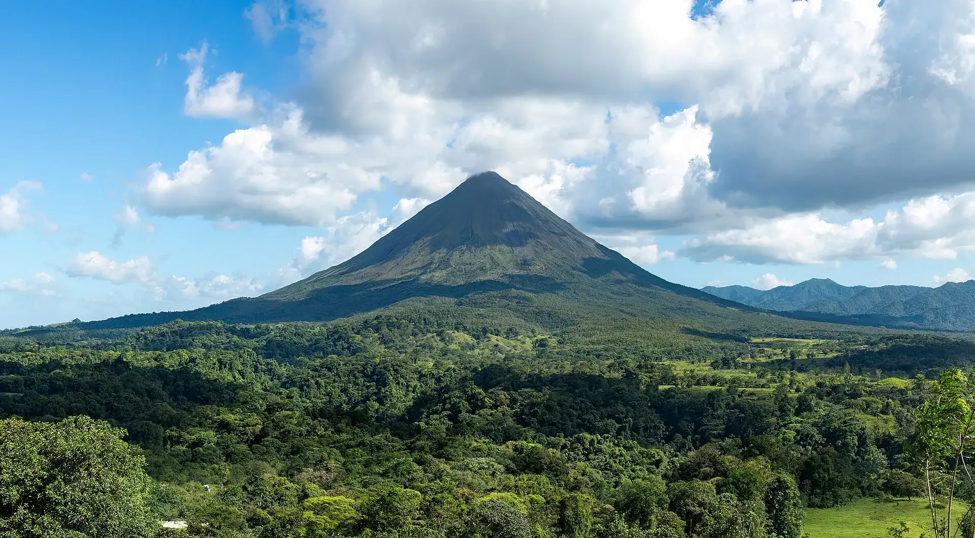 The cone of Arenal volcano rising above rainforest near La Fortuna