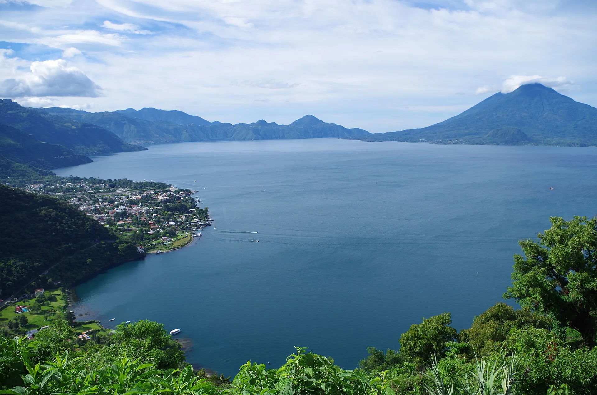 Panoramic view of Lake Atitlán with Panajachel on the shore and three volcanoes on the horizon, Guatemala