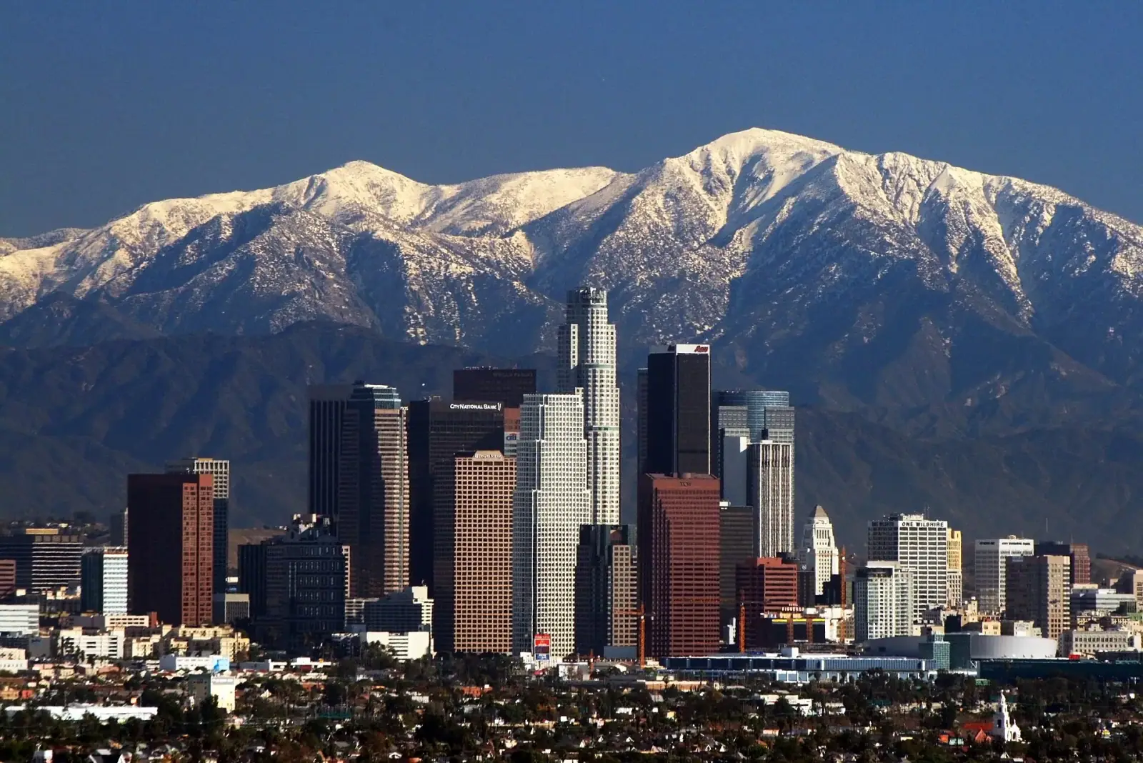Downtown Los Angeles skyline with snow-capped San Gabriel Mountains in the background