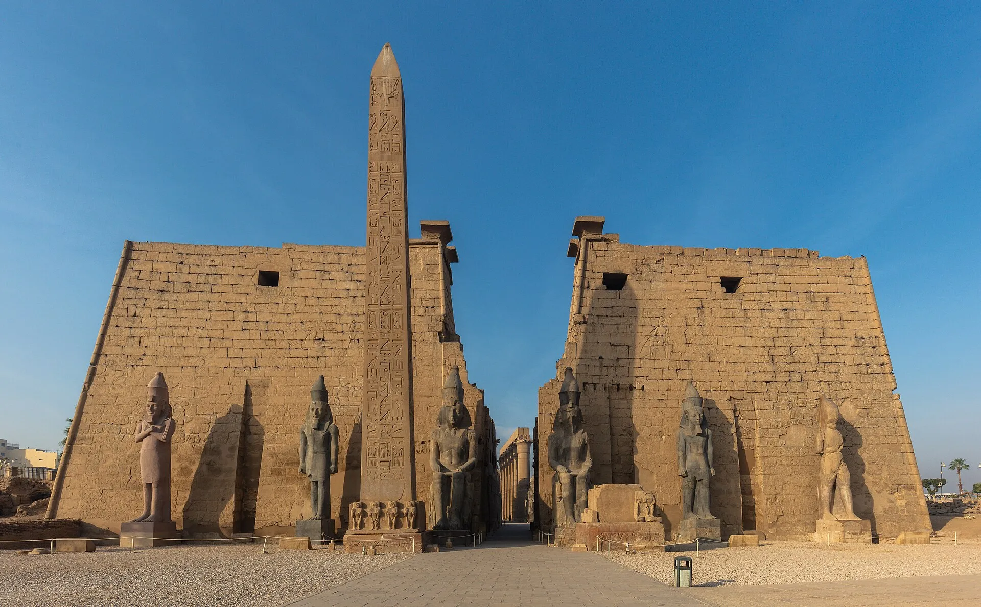 Luxor Temple entrance pylons with obelisk and Ramesses II colossi at golden hour, Luxor, Egypt
