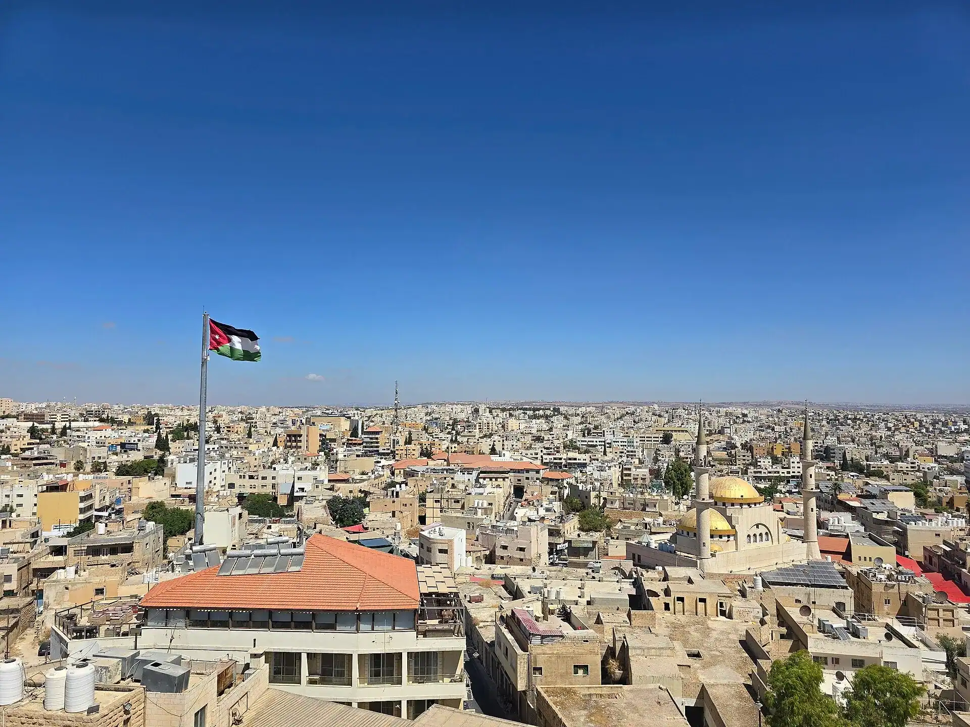The rooftops of Madaba under the Jordanian flag
