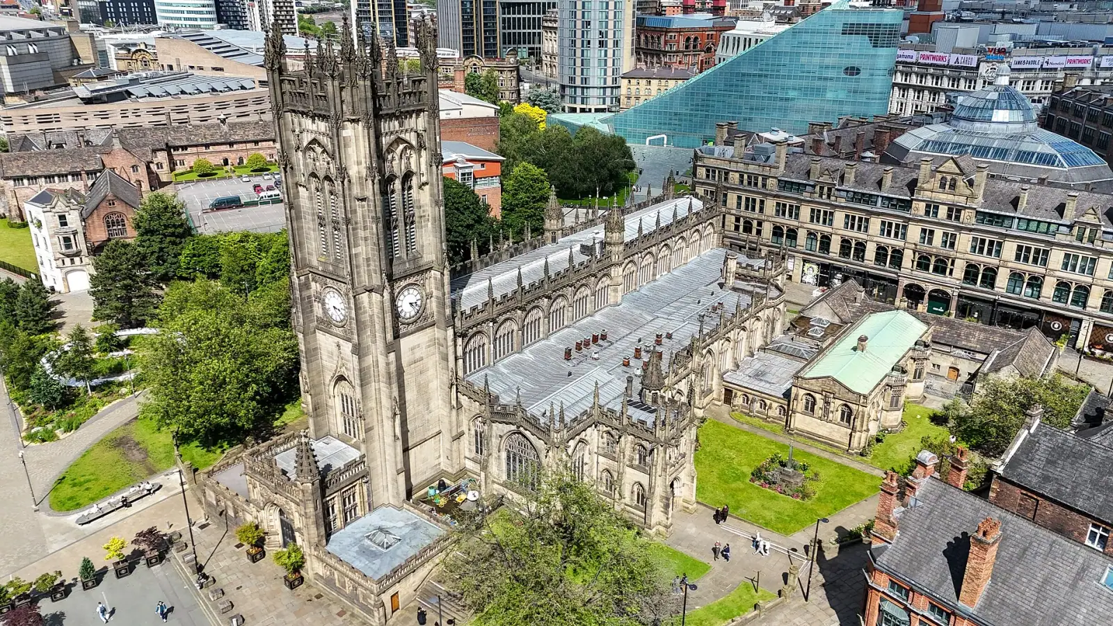 Aerial view of Manchester Cathedral with the city skyline behind it
