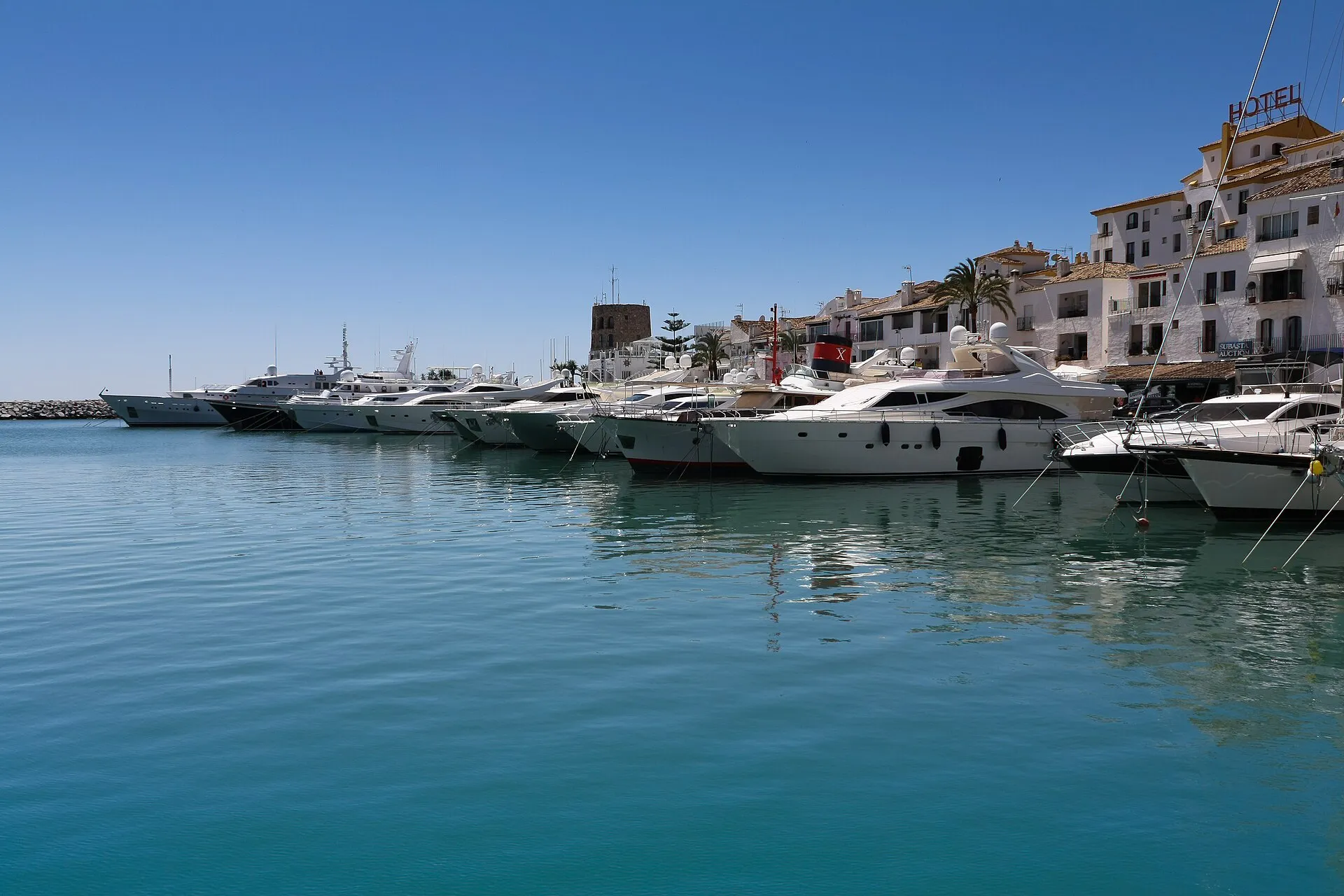 Luxury yachts moored at Puerto Banus marina, Marbella, Spain, under a clear blue sky