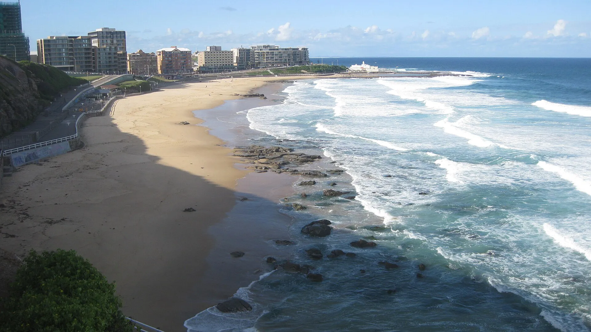 The beach and surf at Newcastle with the city behind