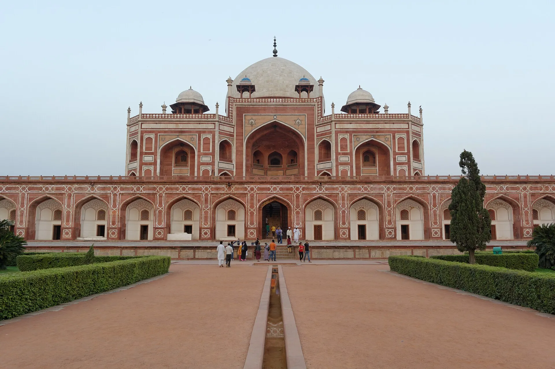 The red sandstone and white marble facade of Humayun's Tomb in Delhi, seen head on down the central water channel of its formal Mughal garden