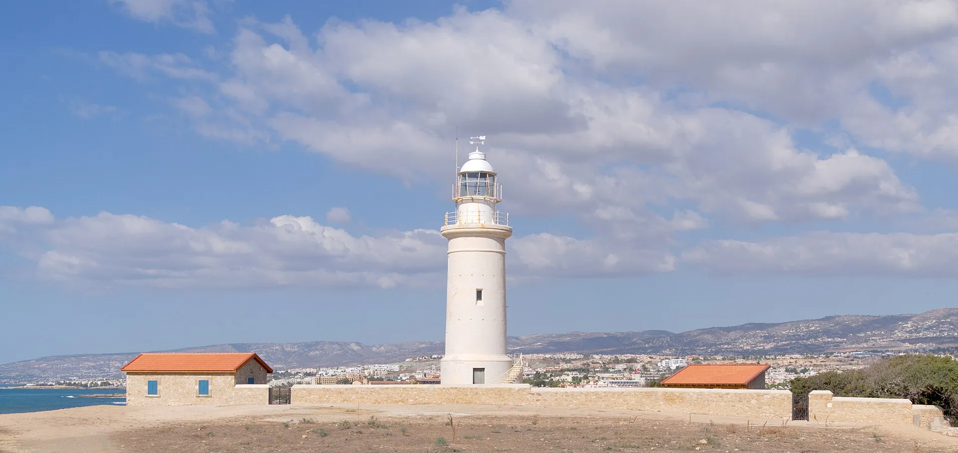 Paphos Lighthouse with the city and Mediterranean Sea in the background