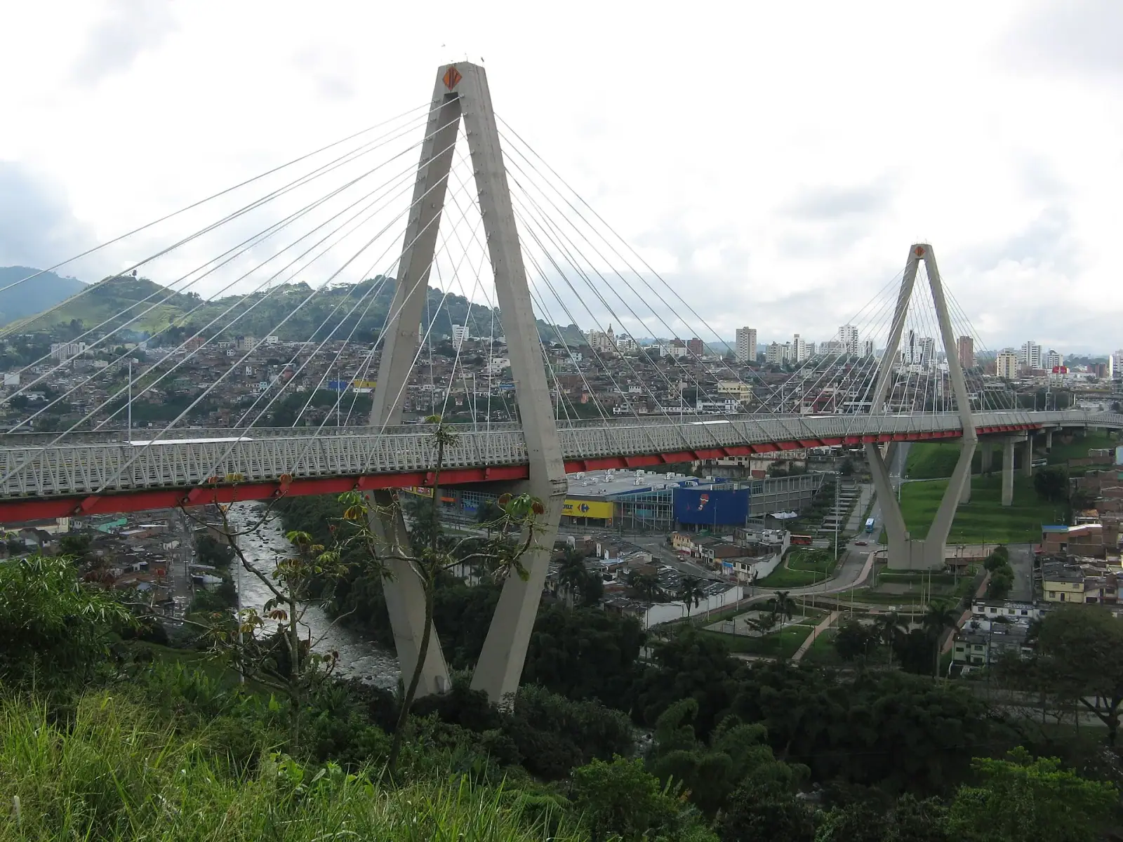 Aerial view of the Viaducto Cesar Gaviria cable-stayed bridge with Pereira city skyline and Andes mountains behind