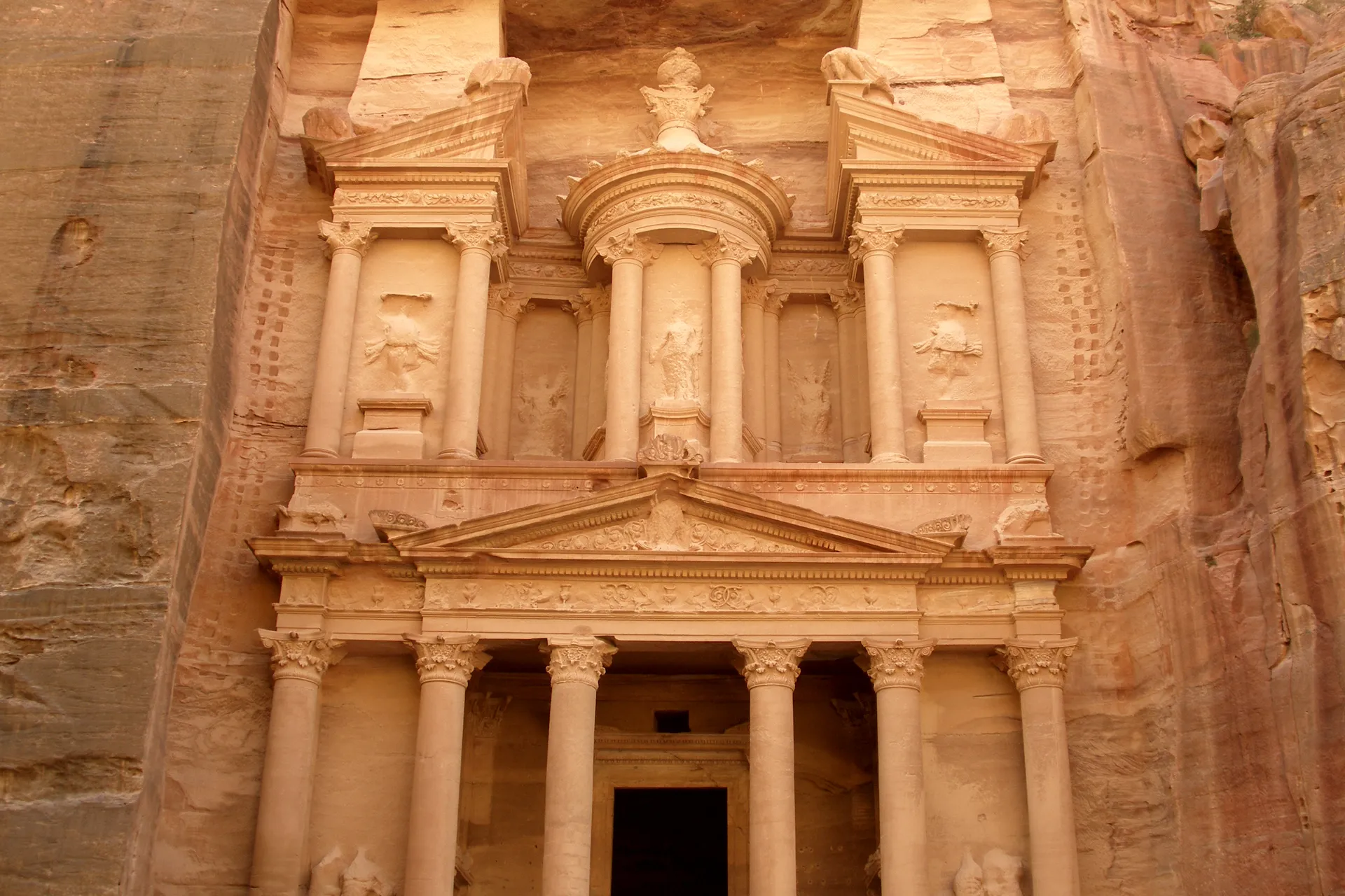 Al-Khazneh, the Treasury of Petra, its ornate rose-red columned facade carved directly into the towering sandstone cliff