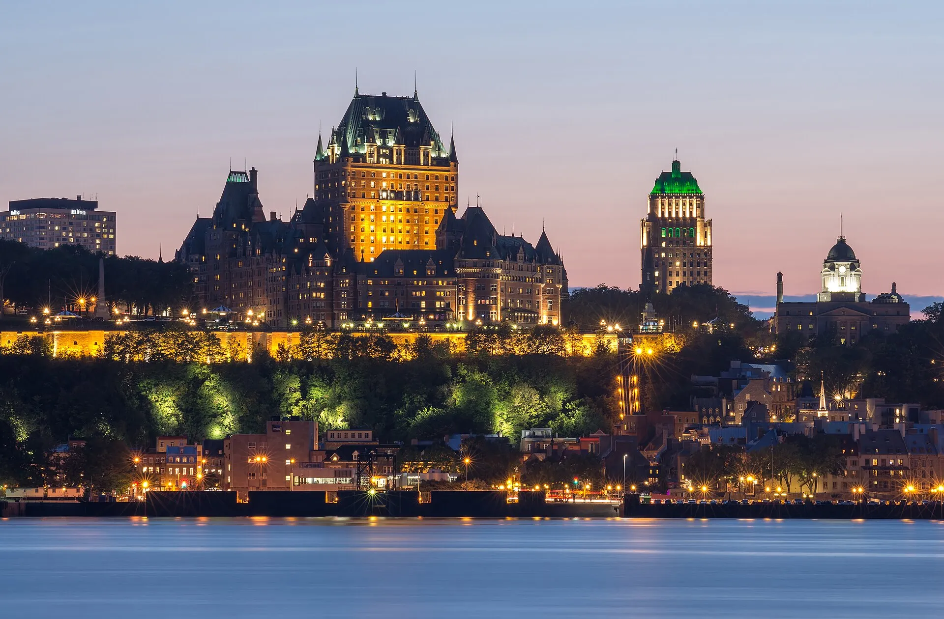 Chateau Frontenac and Old Quebec skyline lit up at dusk, seen across the St. Lawrence River
