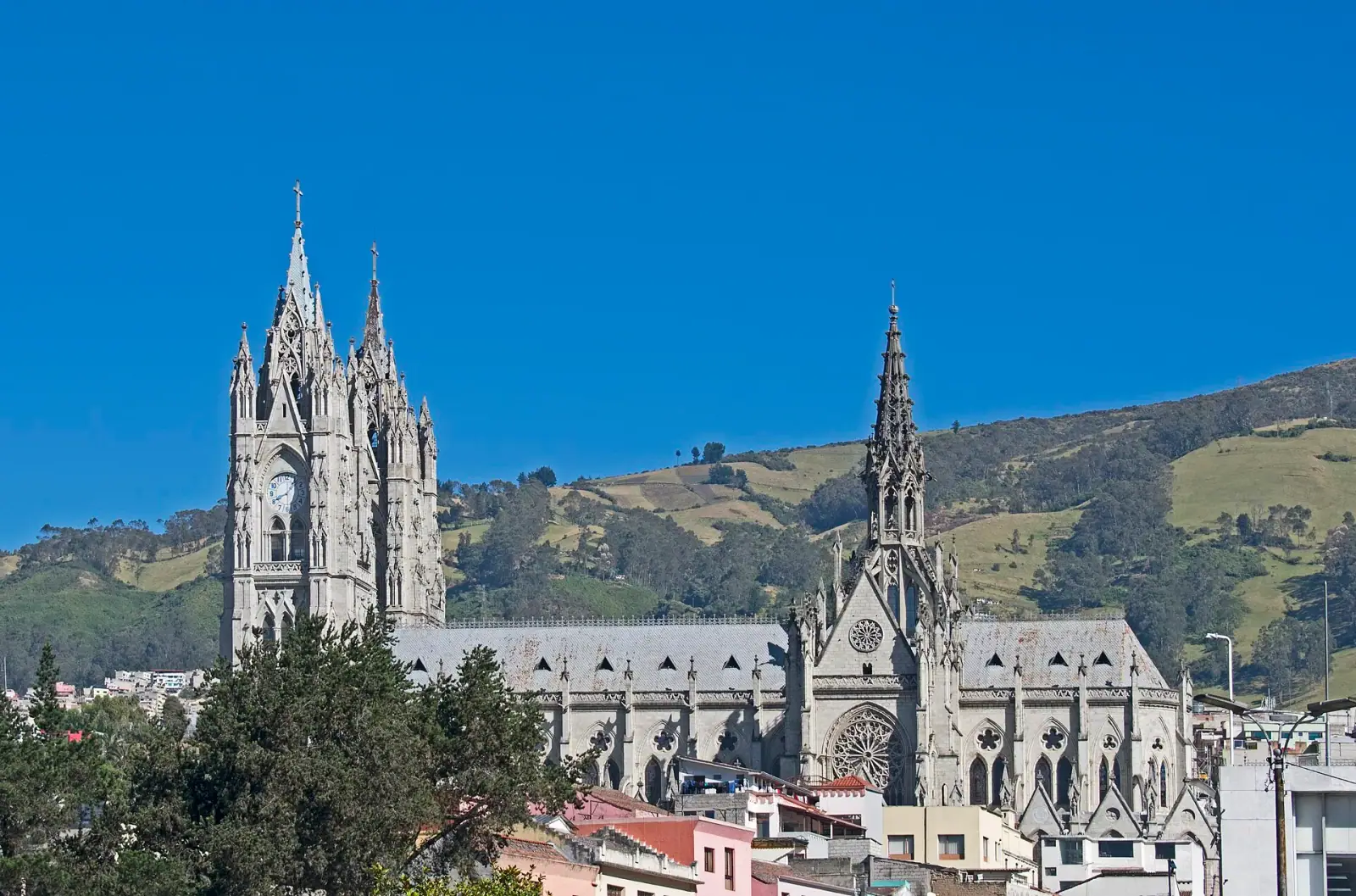 Basilica del Voto Nacional Gothic spires against blue sky and Andean hills, Quito, Ecuador