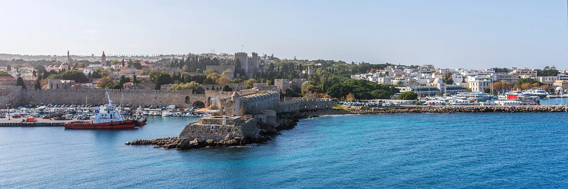Panoramic view of Rhodes old town from the sea, with medieval walls, harbor, and Palace of the Grand Master