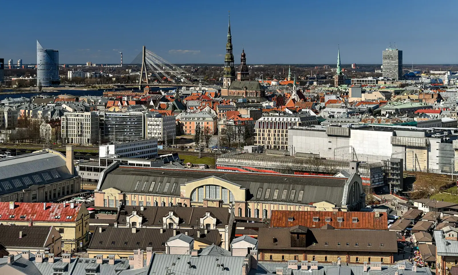 Aerial view of Riga Old Town skyline with cathedral spires, Central Market, and Vansu Bridge