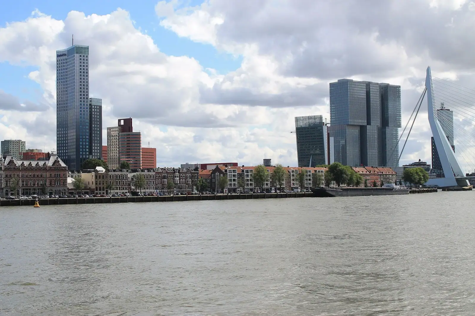 Rotterdam skyline with Erasmus Bridge and De Rotterdam towers seen from across the Nieuwe Maas river