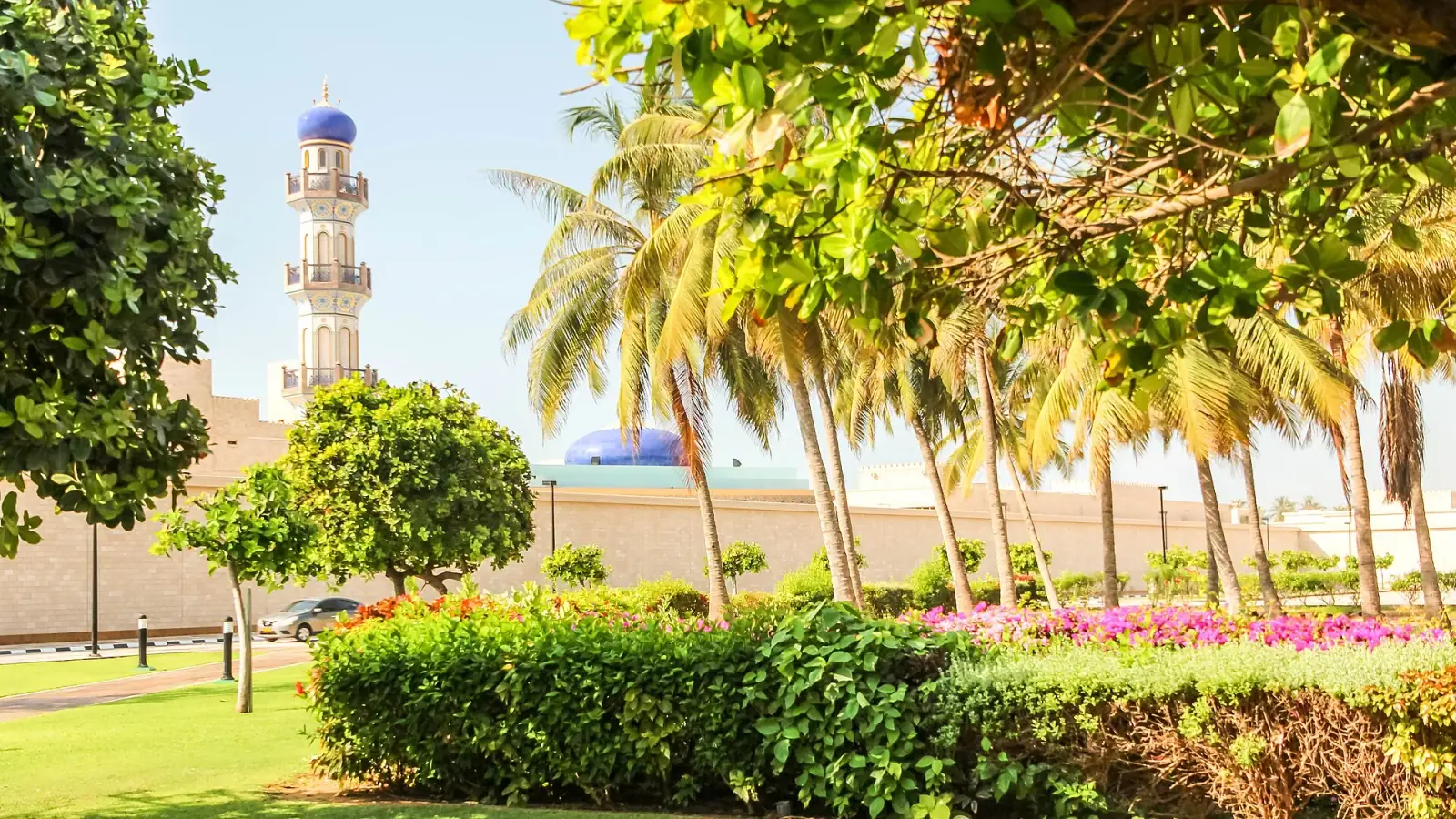 Qasr al-Hosn Palace minaret with tropical gardens and palm trees in Salalah, Oman