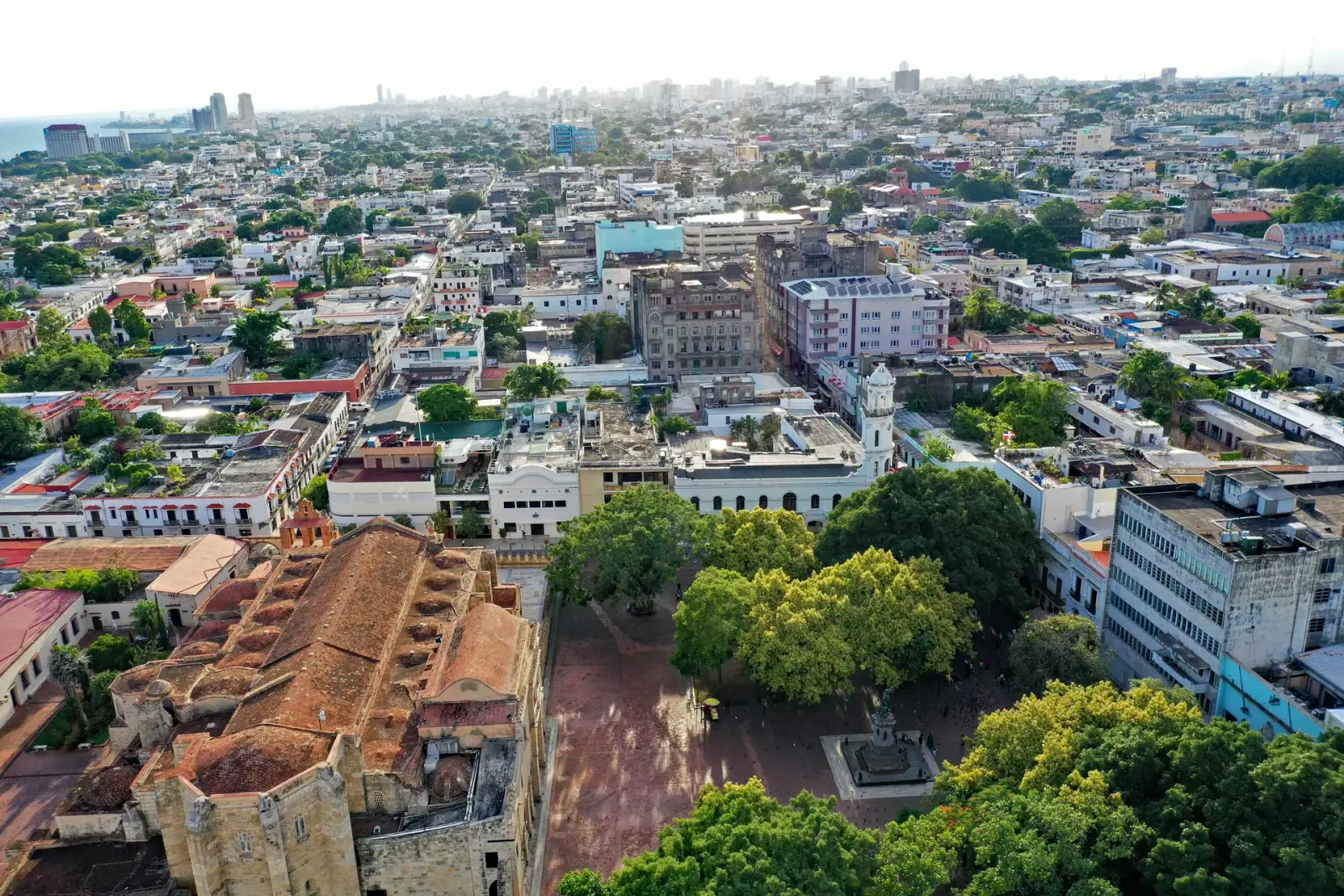 Aerial view of Ciudad Colonial Santo Domingo with Parque Colón, historic cathedral, and modern city extending to the Caribbean Sea
