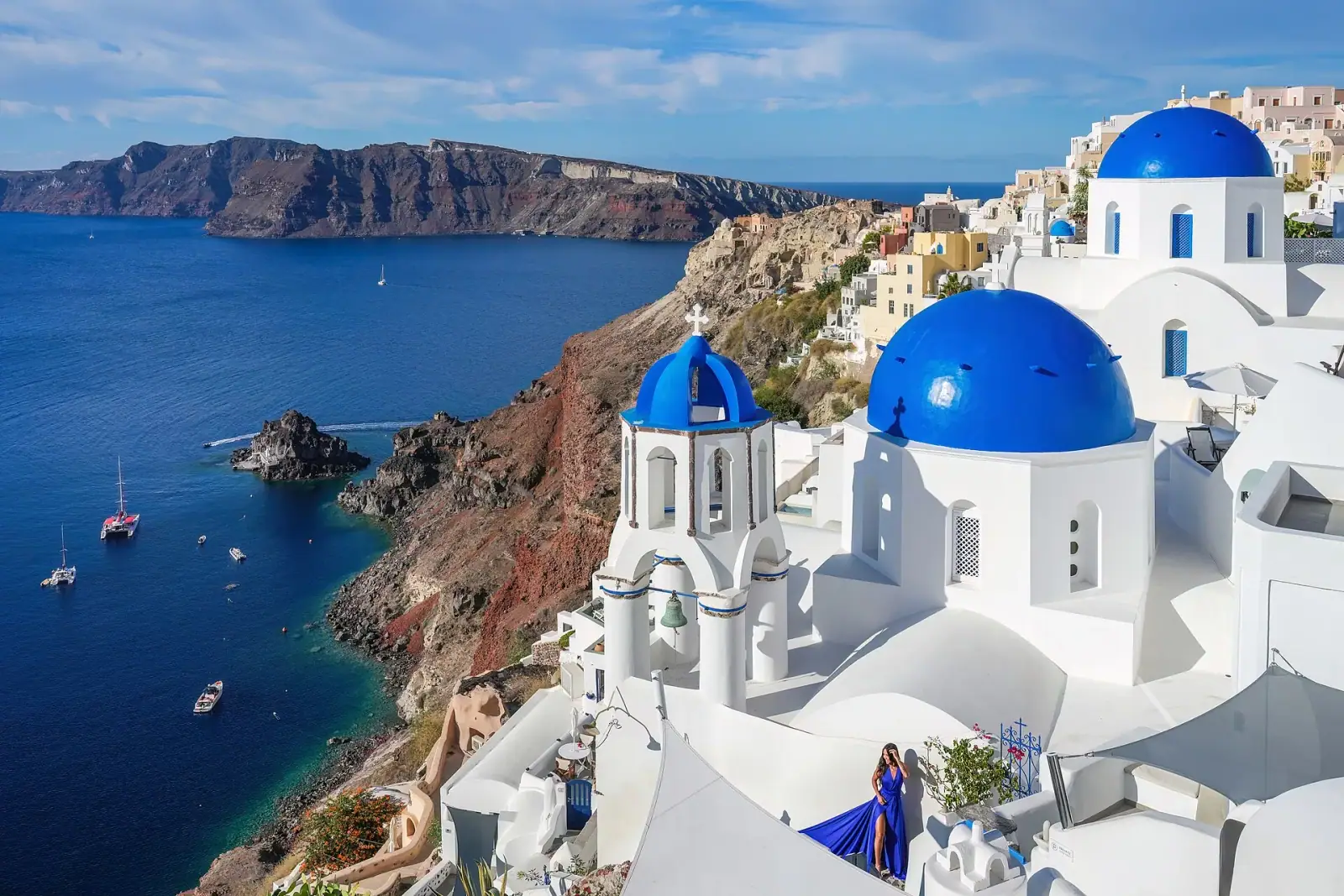 Three blue-domed churches of Oia overlooking the Santorini caldera and Aegean Sea