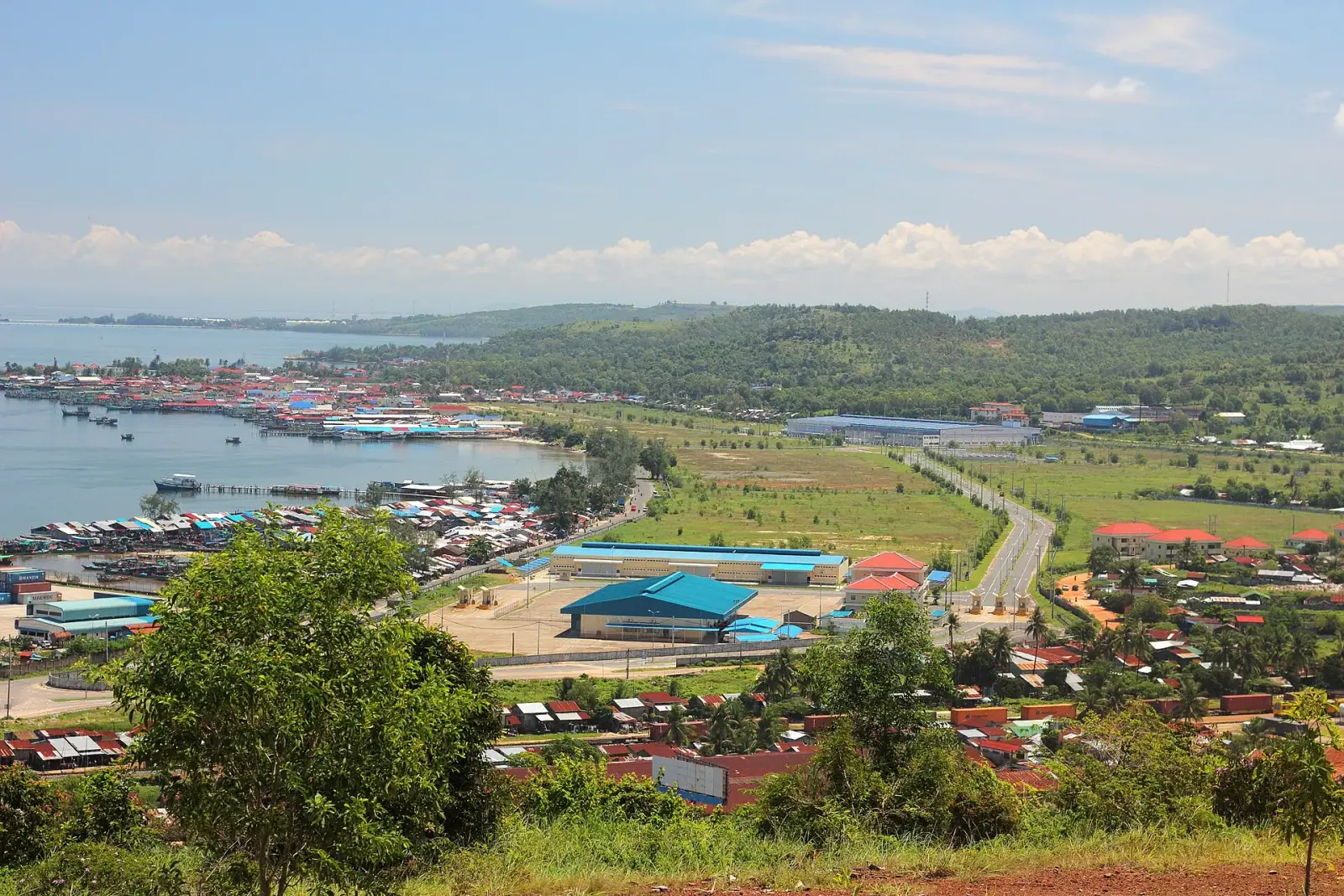 Sihanoukville harbor and fishing village from above, with green hills and the Gulf of Thailand