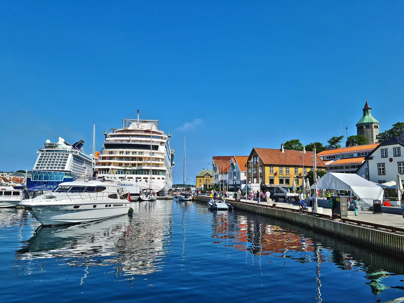 Stavanger harbour with cruise ships, wooden buildings and Valberg Tower on a sunny day