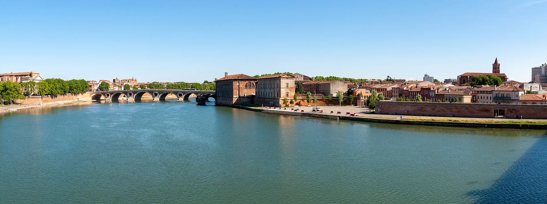 Panoramic view of Toulouse along the Garonne river with Pont Neuf and pink brick city