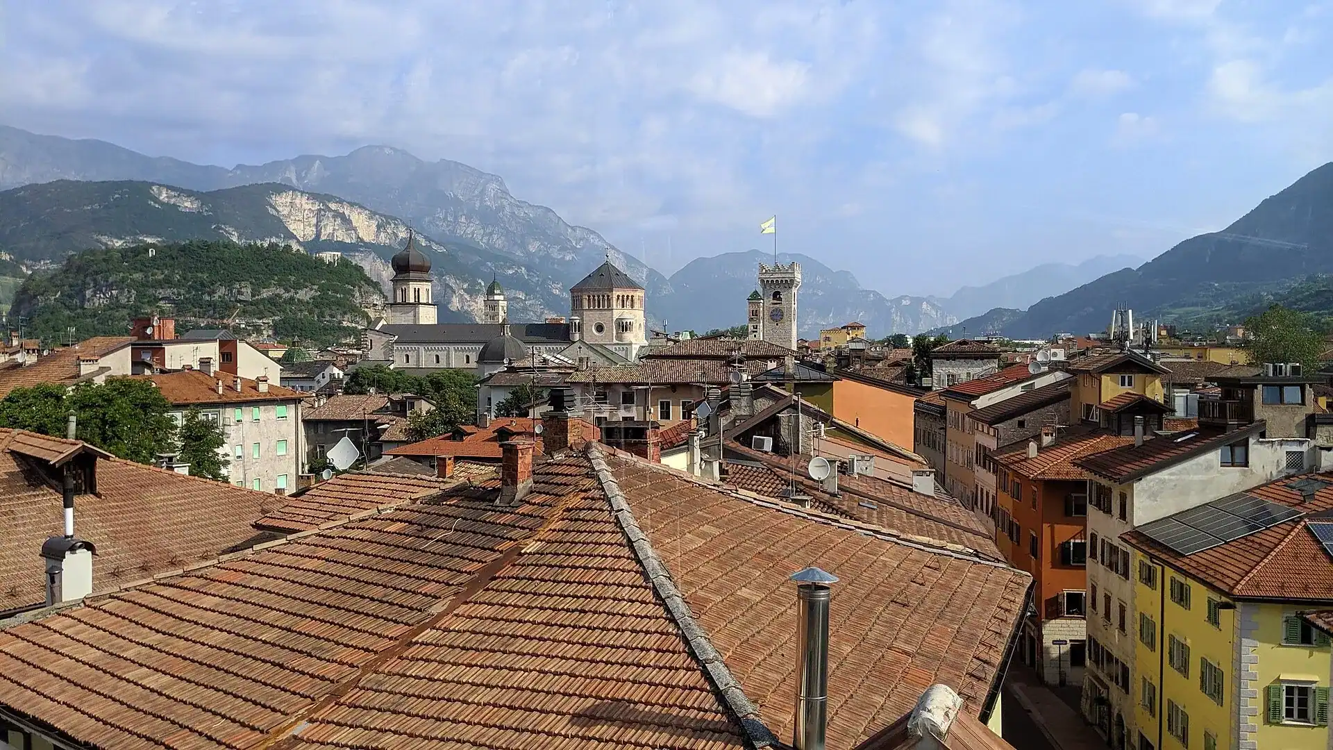 The rooftops of Trento with its castle and the Dolomites behind