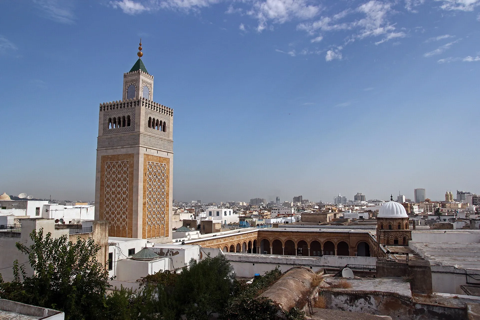 Zitouna Mosque minaret rising above the Tunis Medina rooftops with the city skyline behind