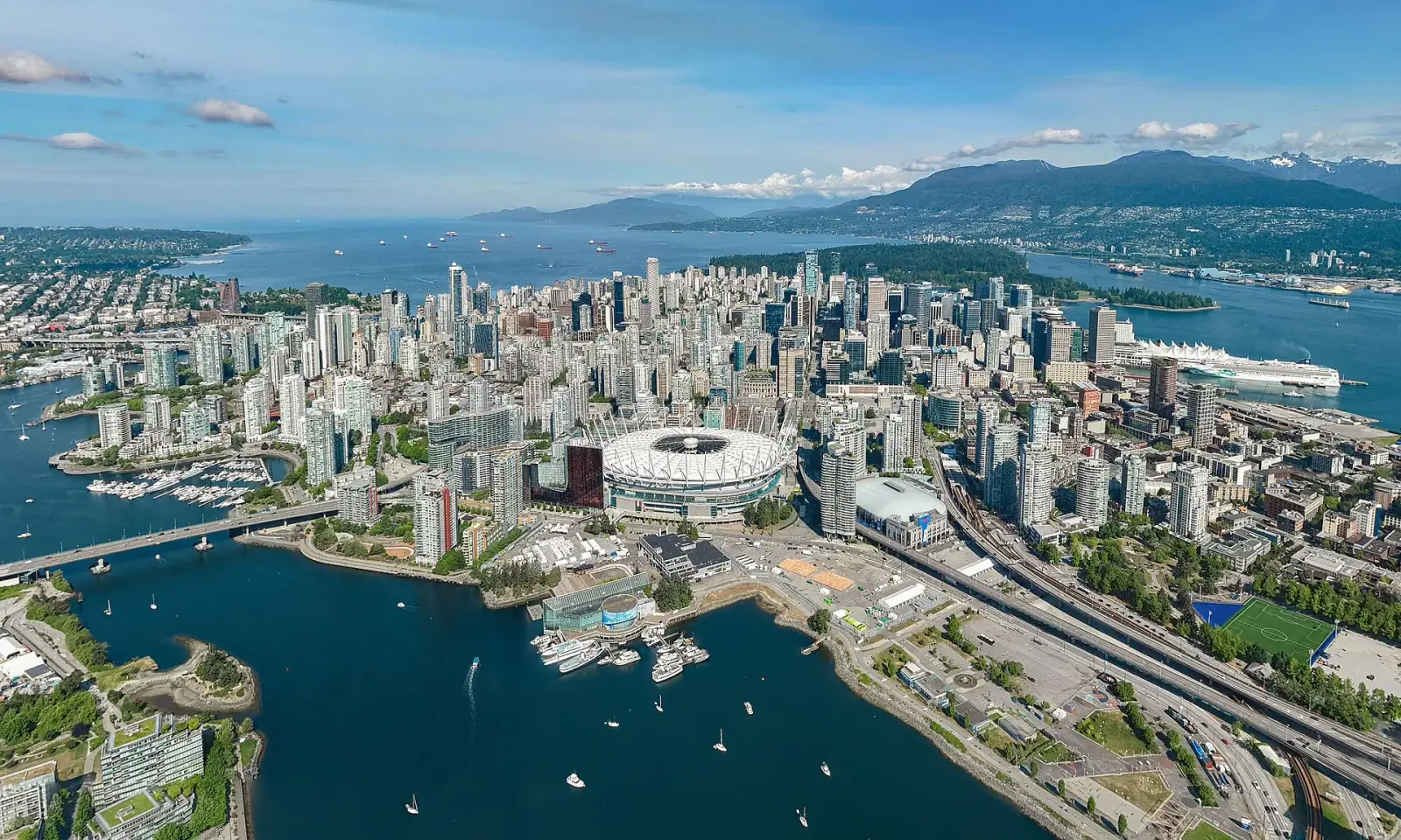 Aerial view of Vancouver skyline with BC Place stadium, False Creek, Canada Place, and North Shore mountains
