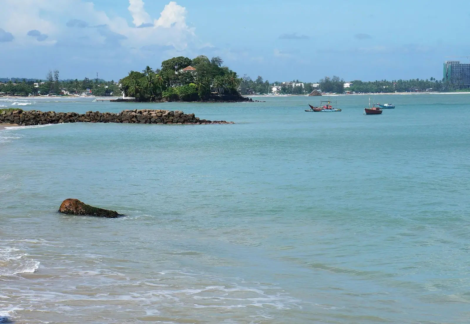 Weligama bay with Taprobane Island and traditional outrigger fishing boats on the beach, Sri Lanka