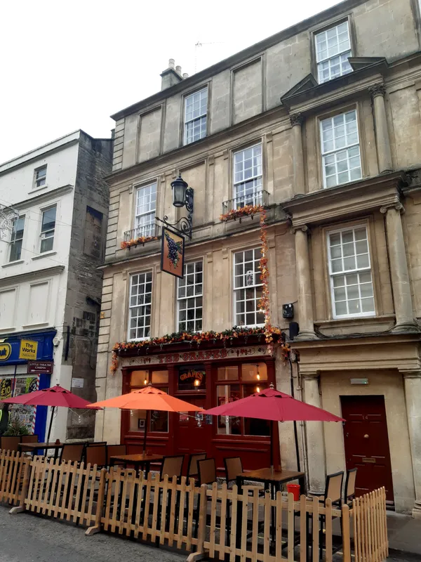 Exterior of The Grapes pub on Westgate Street, Bath, with outdoor seating