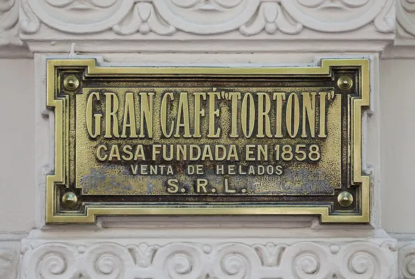 Historic brass plaque on the facade of Gran Cafe Tortoni reading 'Casa Fundada en 1858'