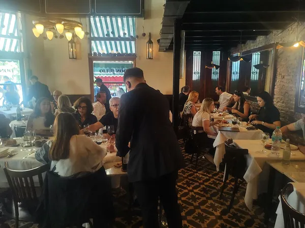 Busy dining room interior of Don Julio parrilla in Palermo with 'Don Julio' awning visible through window