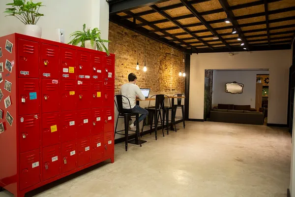 Interior of La Maquinita Co. coworking space in Palermo Soho with red lockers and workspace