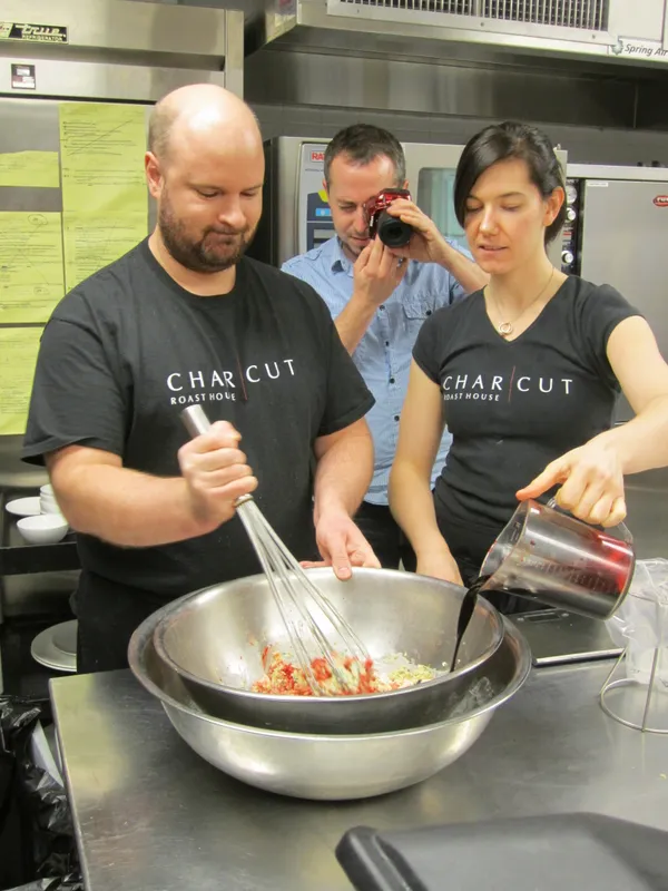 CHARCUT Roast House kitchen staff in branded shirts preparing food