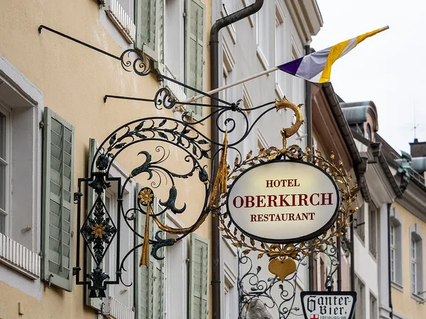 Decorative wrought-iron sign reading Hotel Oberkirch Restaurant on the facade of Boutiquehotel Oberkirch in Freiburg