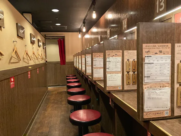 Interior of Ichiran Hakata ramen restaurant showing individual numbered dining booths, Fukuoka